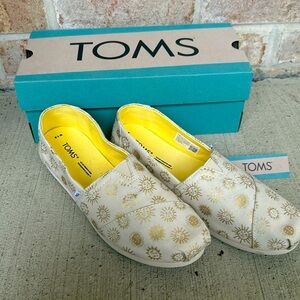 Women’s size 7.5 Toms, limited edition gold sun design. NEVER WORN.